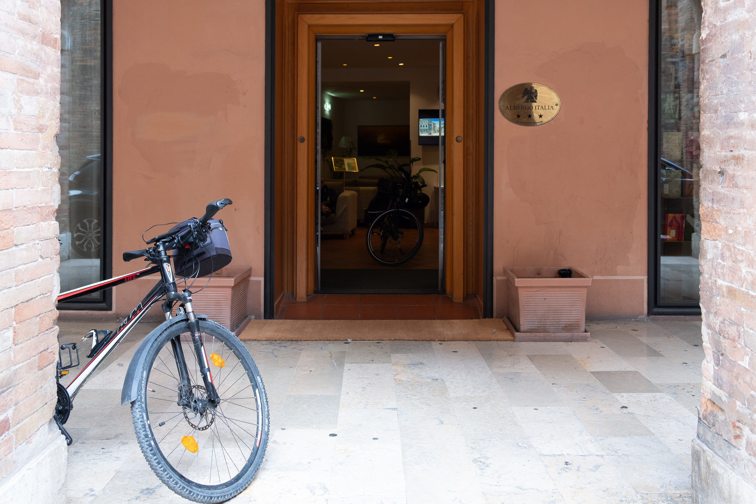 Vor dem Albergo Italia in Urbino – das Rad lehnt am Eingang